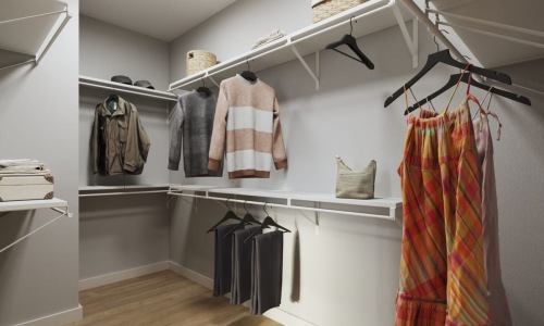 a closet with clothes hanging up